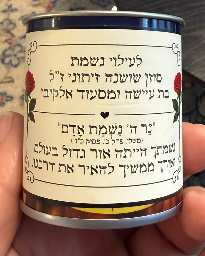 הצד השני של הנר: ״לעילוי נשמת״ ושמה, ״נר ה׳ נשמת אדם״ והקדשה קצרה, בין שני ורדים אדומים