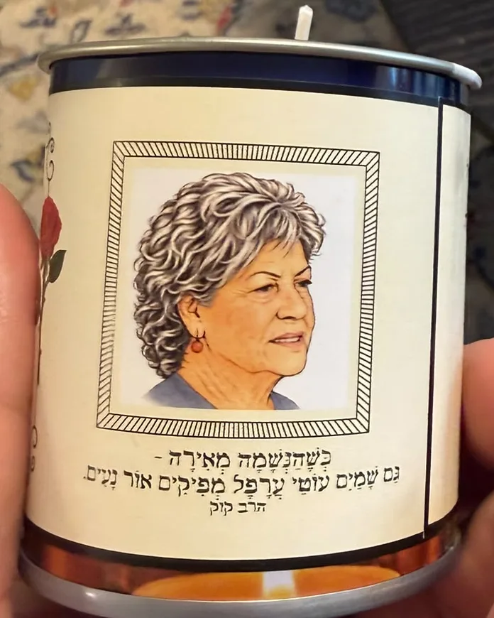 נר זיכרון בפחית. על העטיפה דיוקן מאויר של אמה של נאוה, ומתחתיו ציטוט מהרב קוק